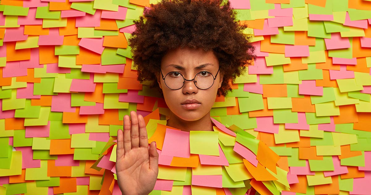 A young woman covered in stickers symbolizing boundaries, personal and porfessional